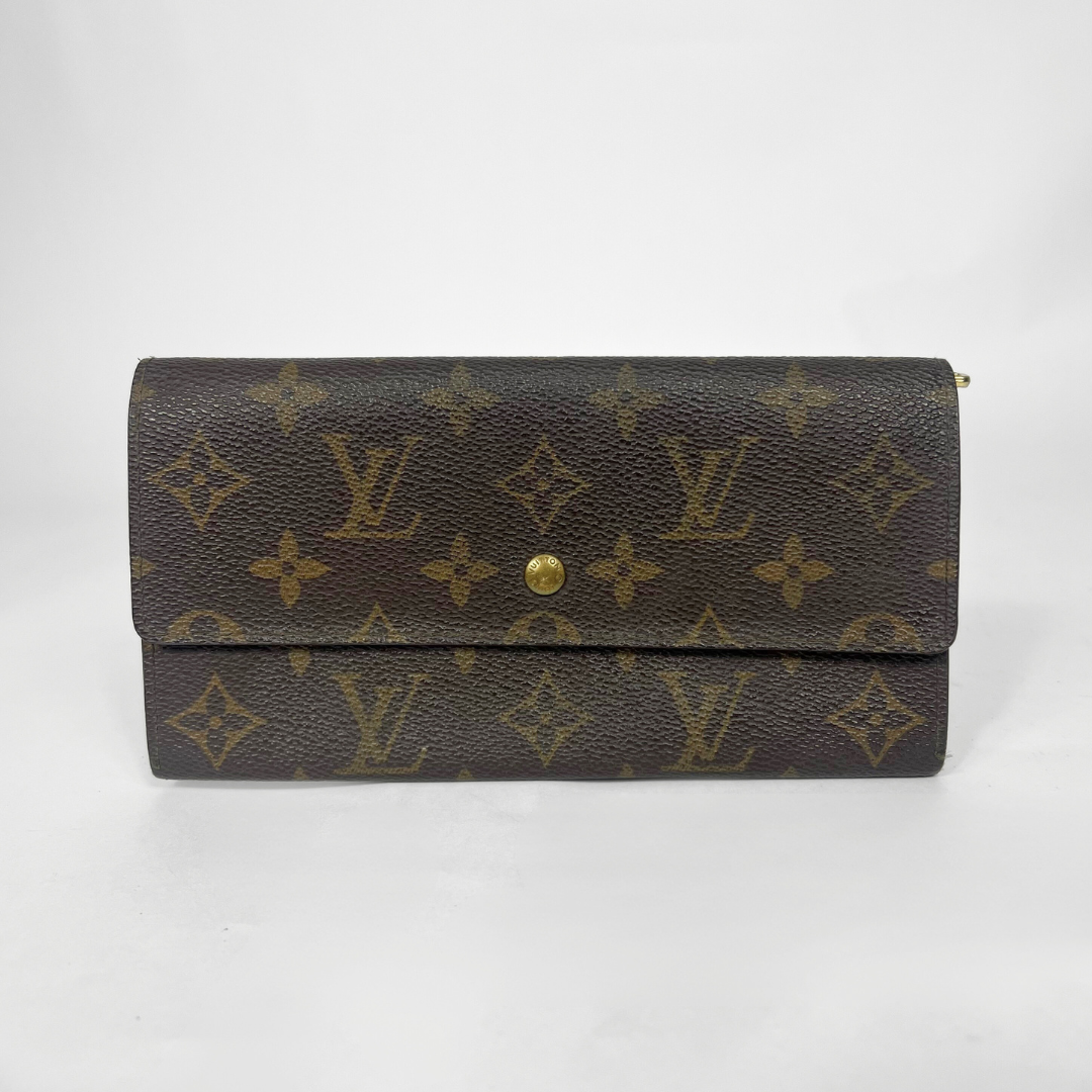 Louis Vuitton wallet with monogram pattern on a white background