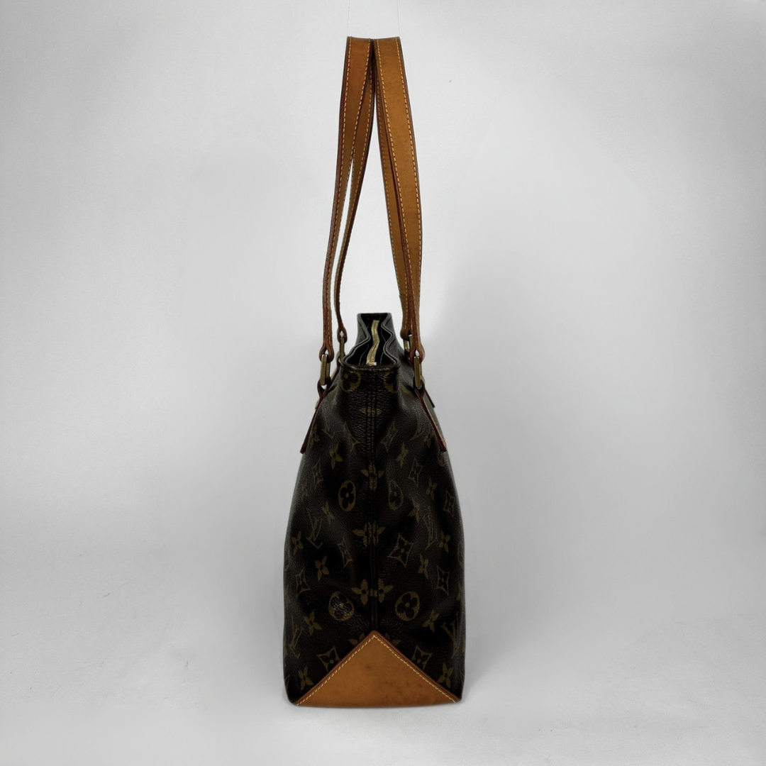 A Louis Vuitton monogram canvas bucket bag with tan leather trim and shoulder straps, shown from the back against a light gray background.