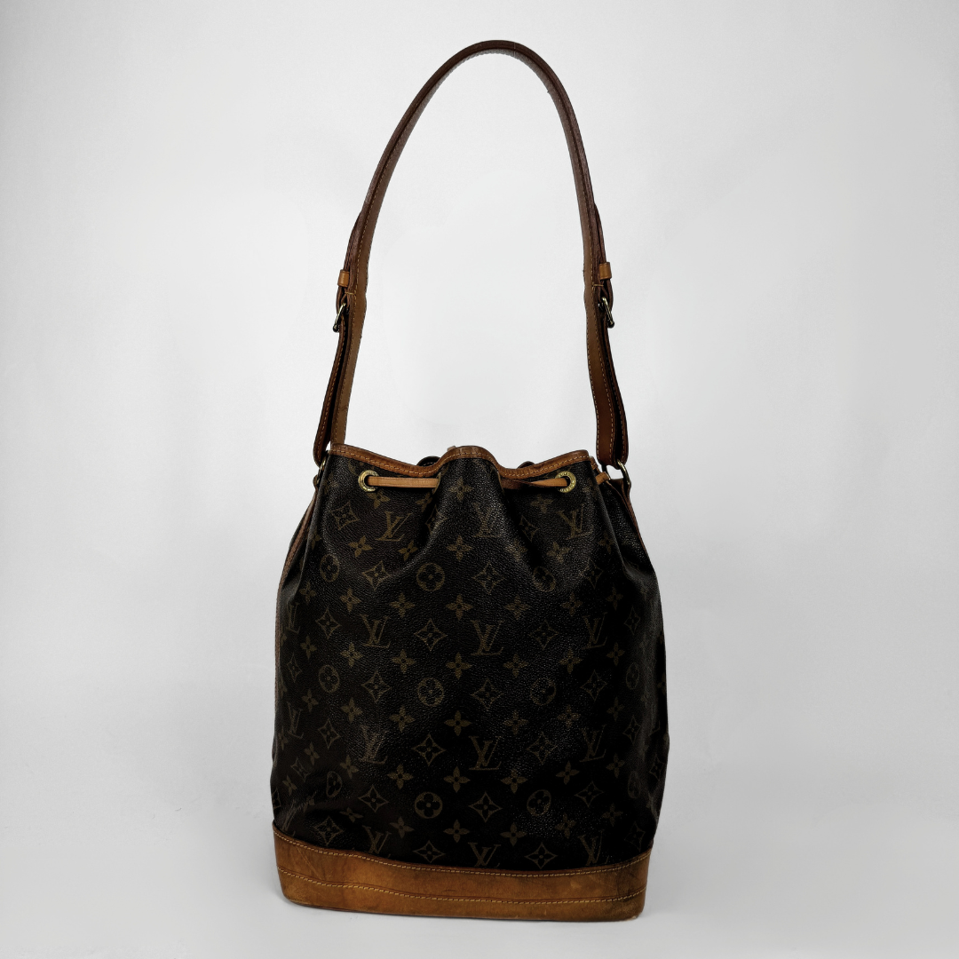 A Louis Vuitton monogram canvas bucket bag with brown leather trim and shoulder strap, shown against a plain light gray background.