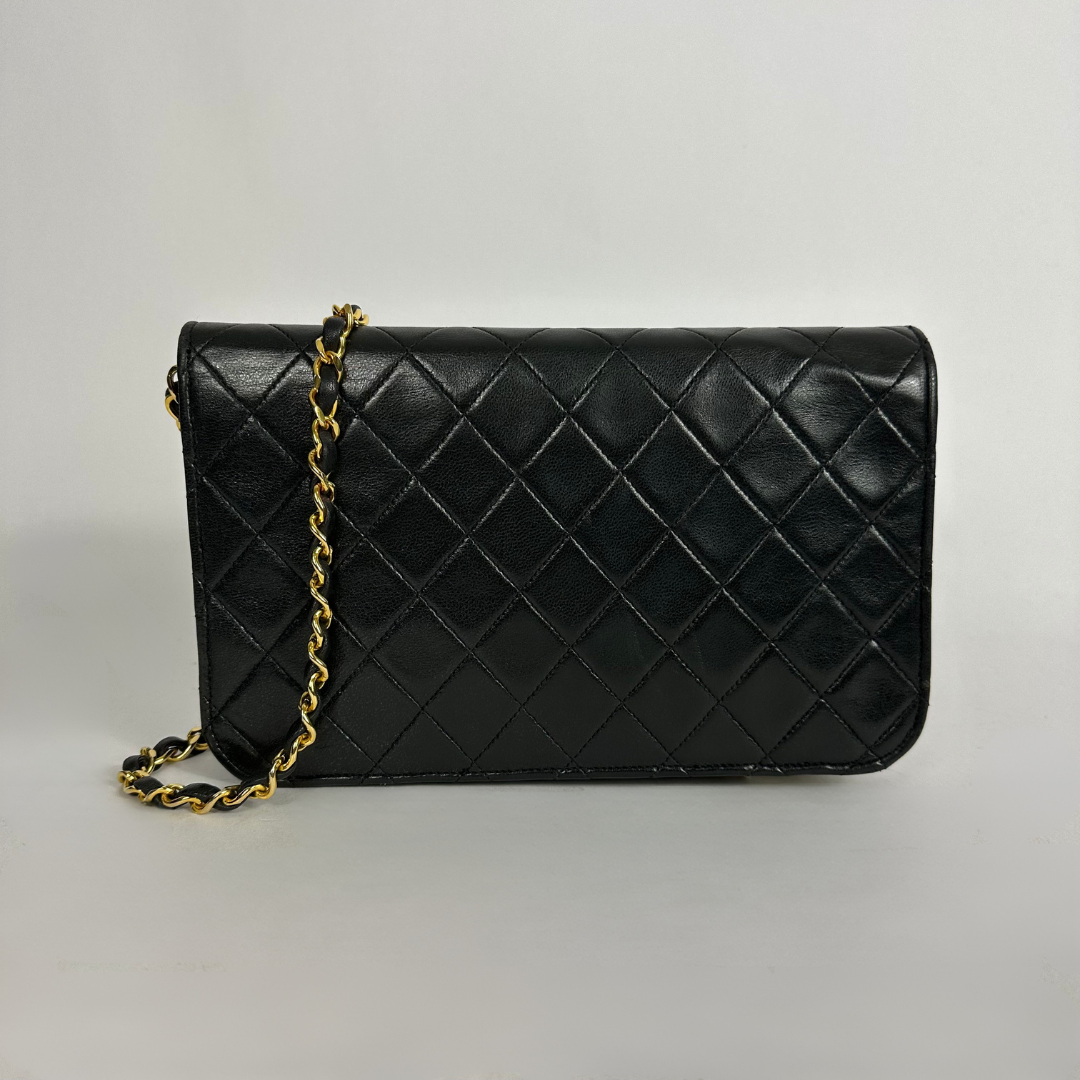 Black Chanel bag on white background