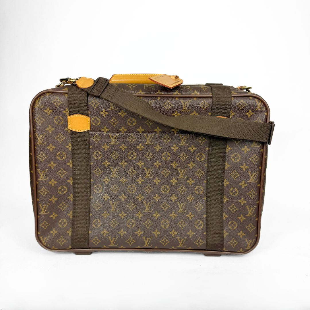 Brown suitcase with yellow accents and monogram pattern on a white background