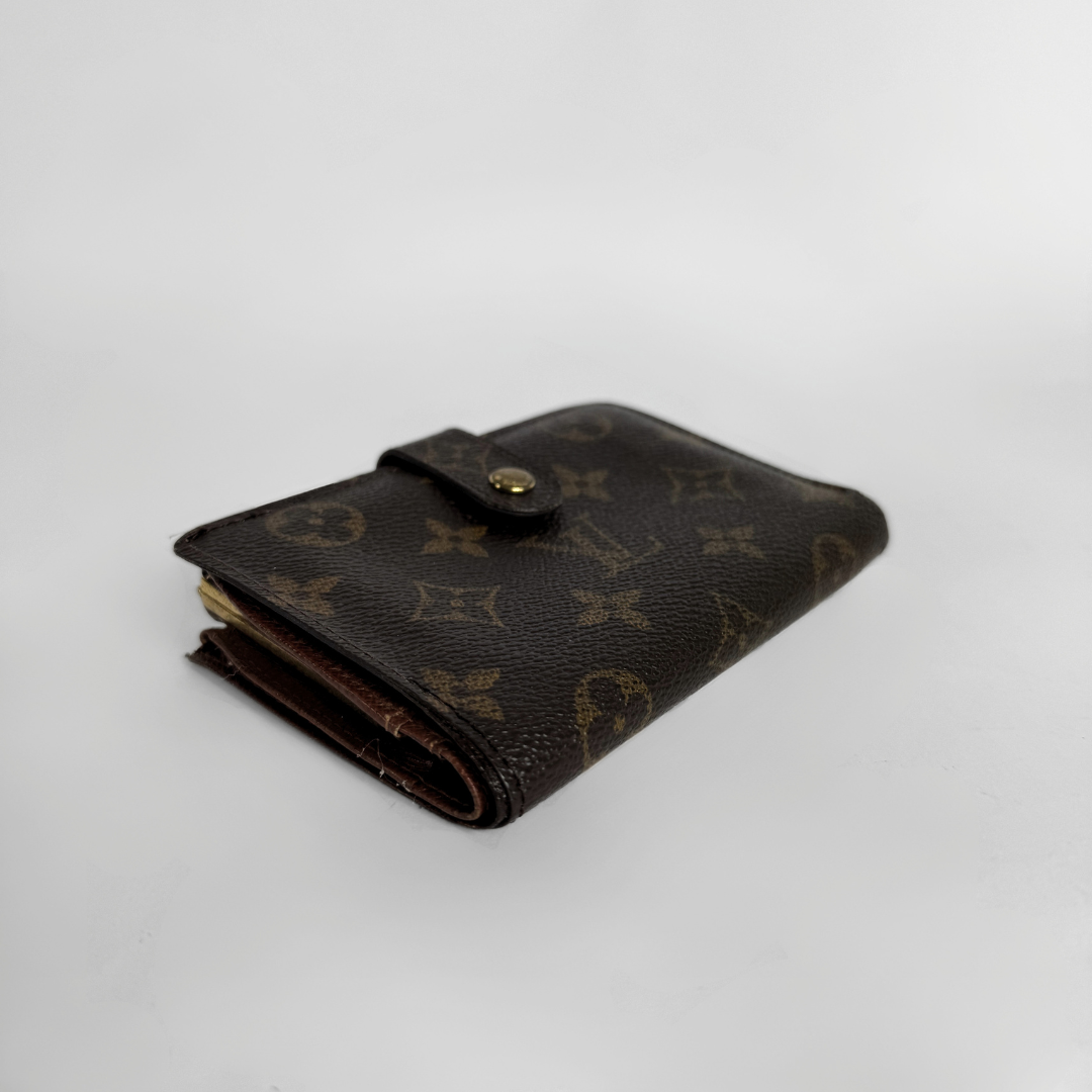 A Louis Vuitton monogram bifold wallet in dark brown coated canvas with gold-tone hardware, photographed on a light gray background.