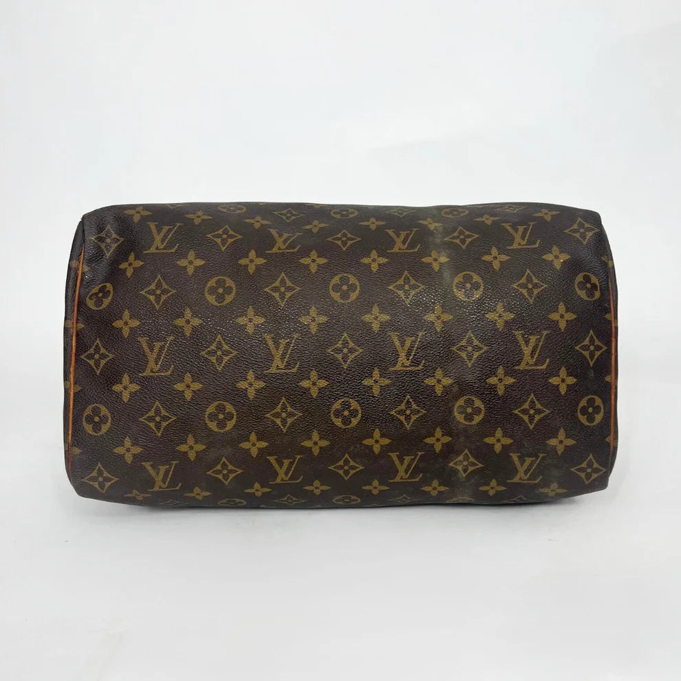 Brown leather bag with monogram pattern on a white background