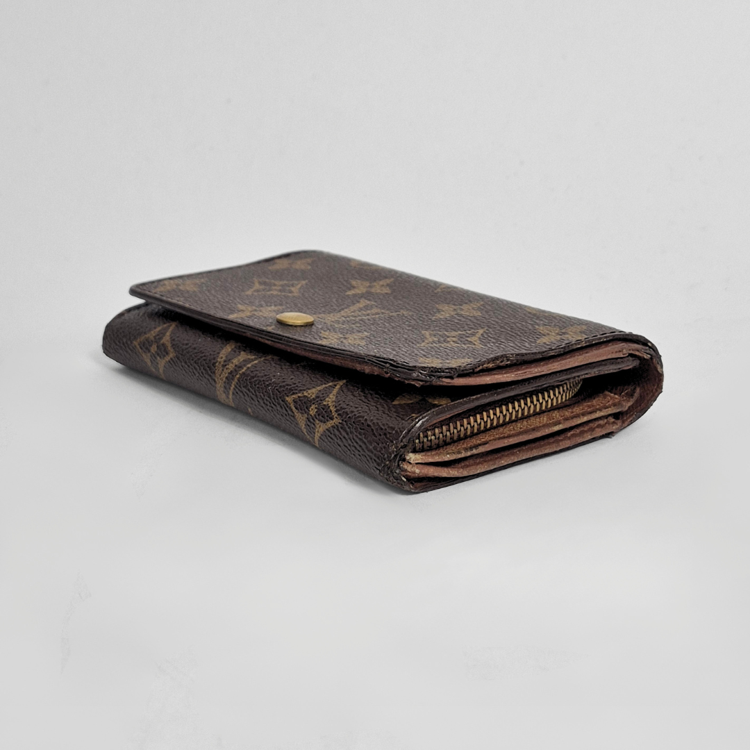 Louis Vuitton wallet with monogram pattern on a light gray background