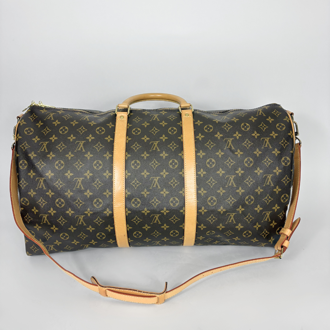 Designer duffel bag with monogram pattern on a gray background