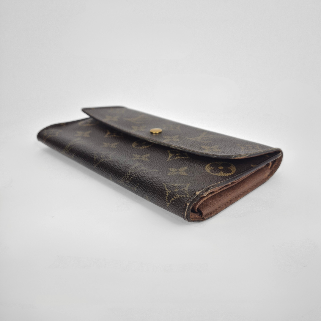 Designer wallet with monogram pattern on a light gray background
