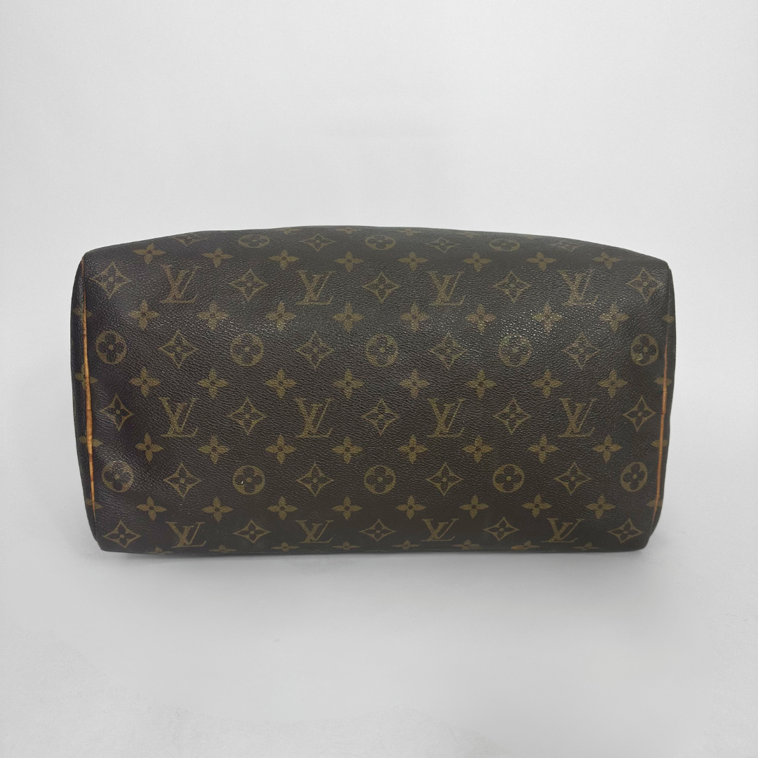 Brown handbag with a monogram pattern on a white background