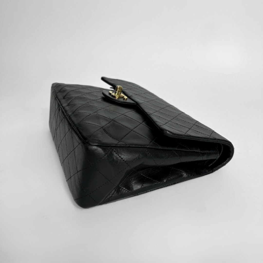Black quilted handbag on a light gray background