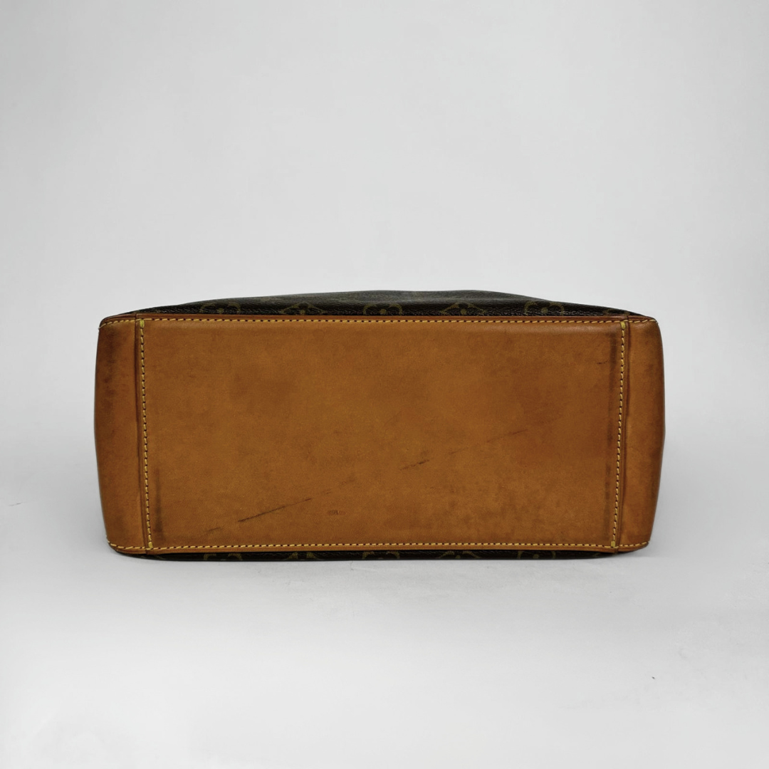 A Louis Vuitton monogram canvas and brown leather tote bag shown from the bottom front view, on a light gray background.