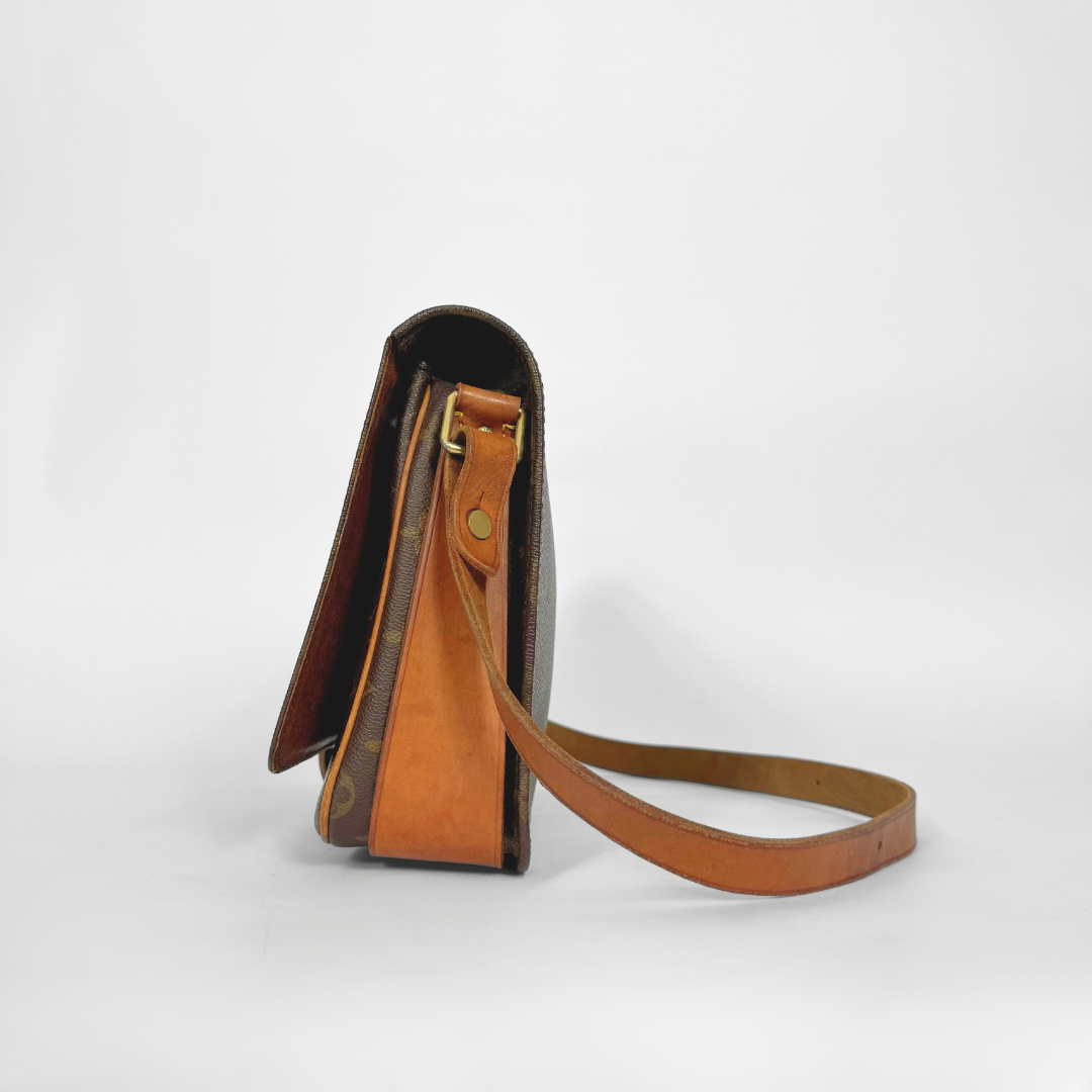 Brown leather handbag with a strap on a white background