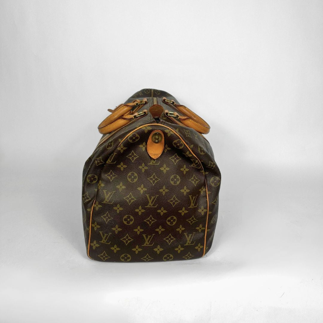 Brown monogram duffel bag with tan leather handles on a white background