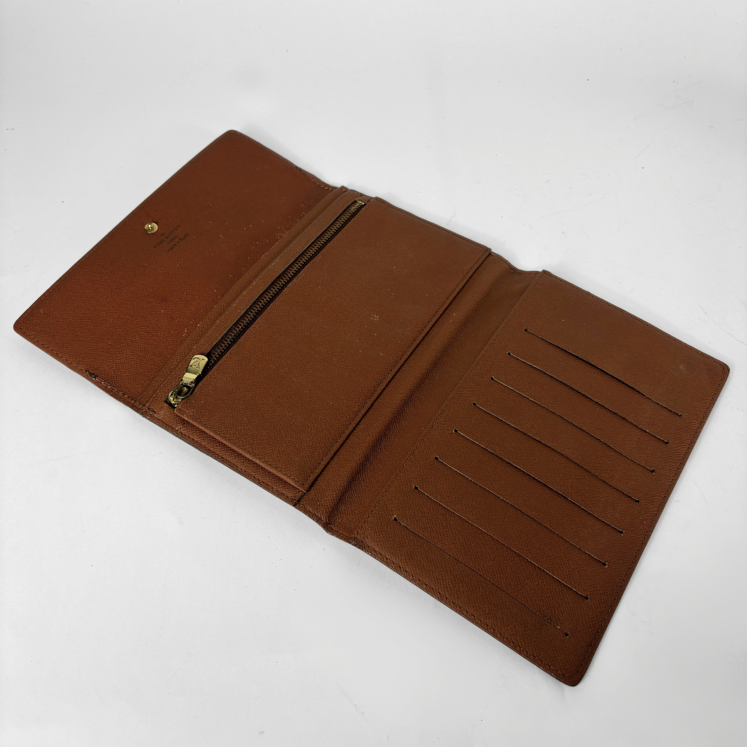 An open brown leather wallet with multiple card slots, a zippered pocket, and a gold-tone zipper pull, photographed on a plain white background.