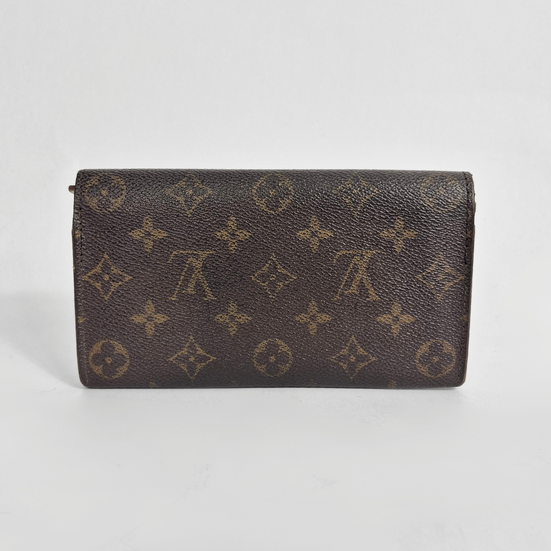 Designer wallet with monogram pattern on a light gray background