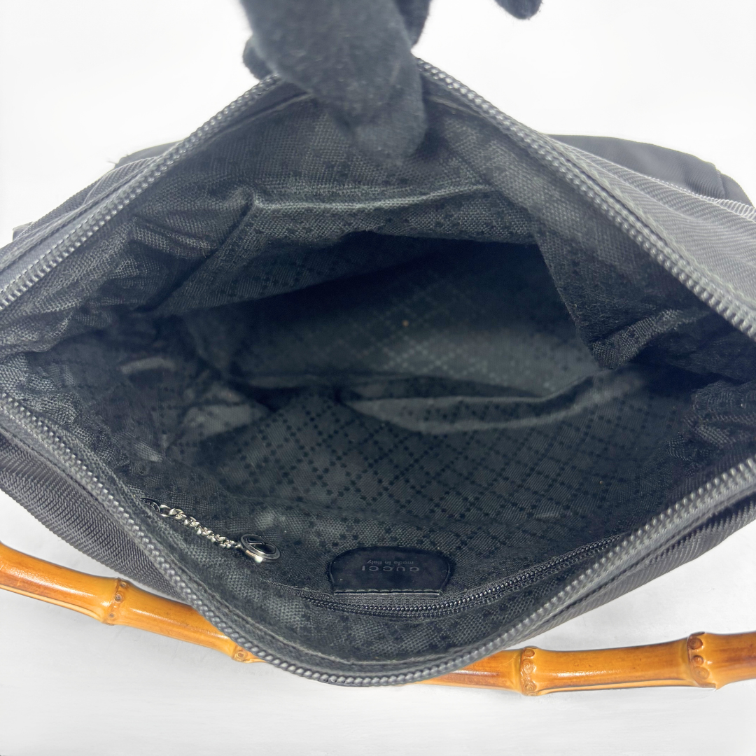 Black handbag with a bamboo handle on a white background