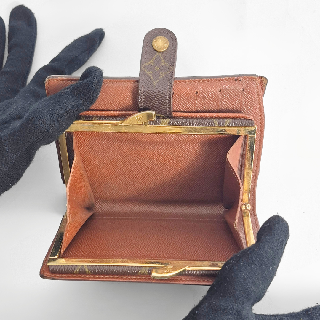 Brown leather wallet with gold accents held open 