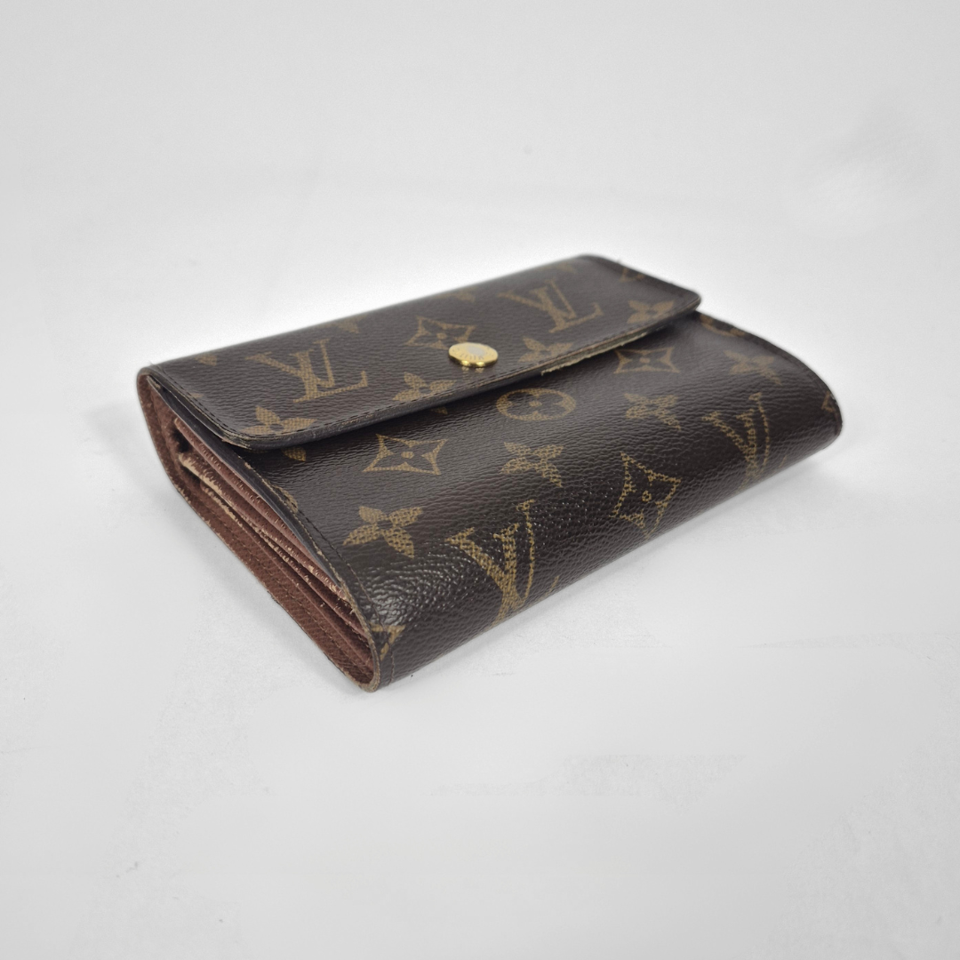 Brown wallet with gold monogram pattern on a white background