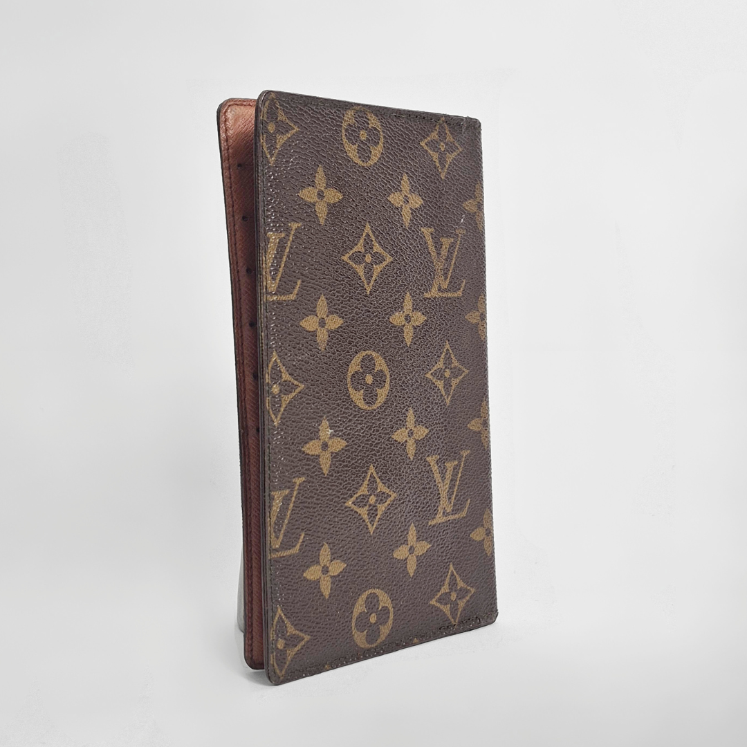 Louis Vuitton wallet with monogram pattern on a light gray background