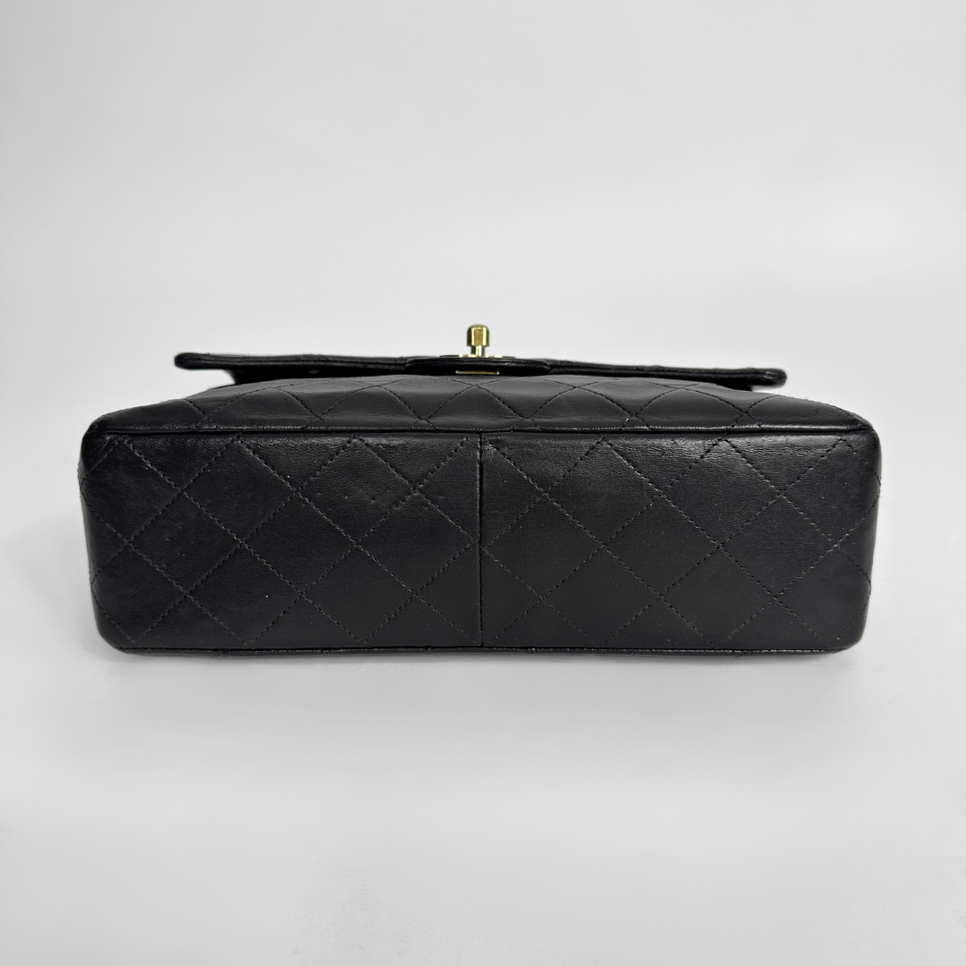 Black quilted handbag on a light gray background