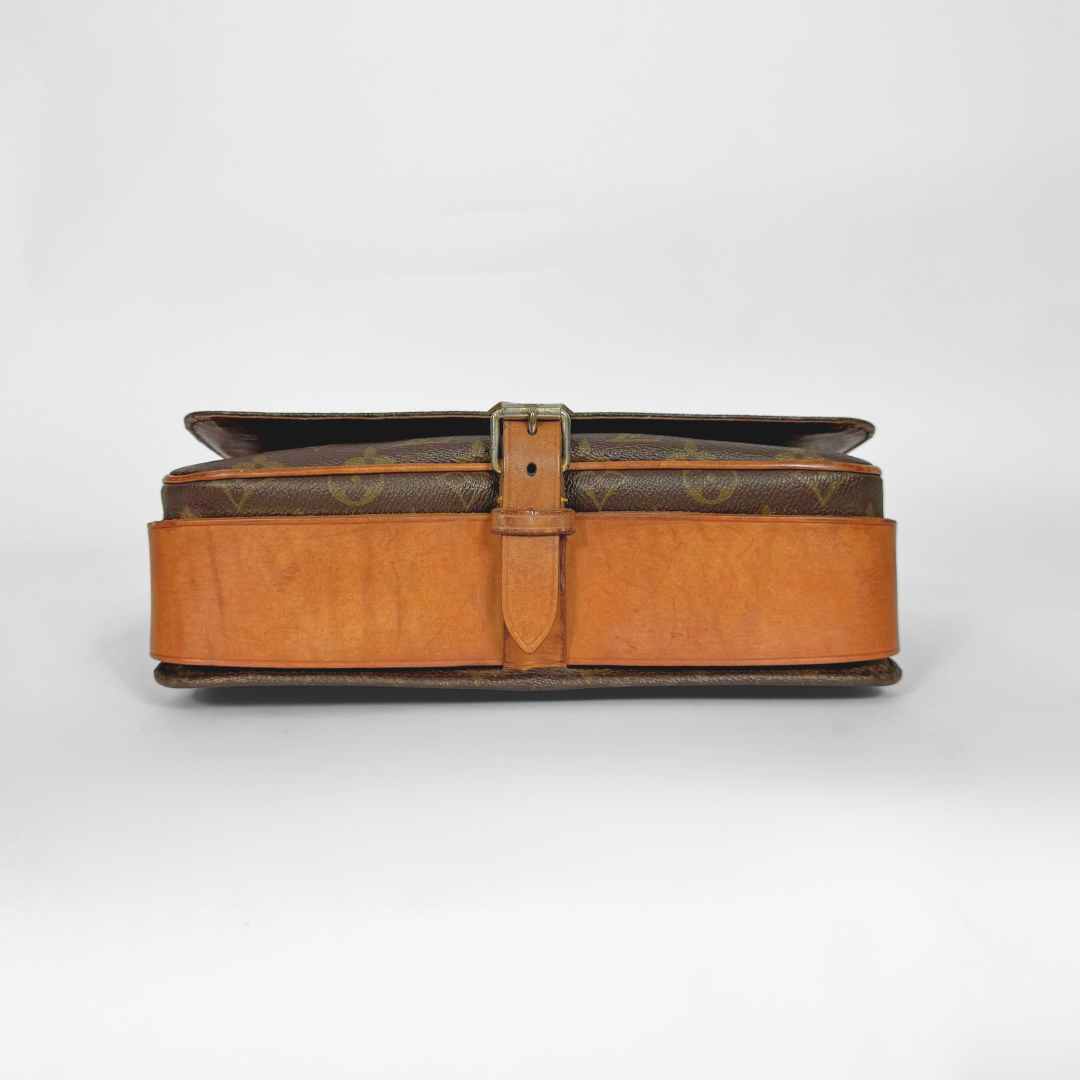 Brown leather suitcase with a strap on a white background