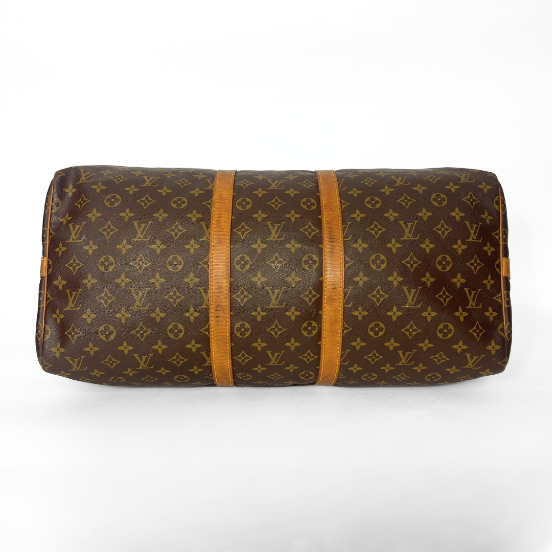 Brown monogram patterned bag with wooden accents on a white background