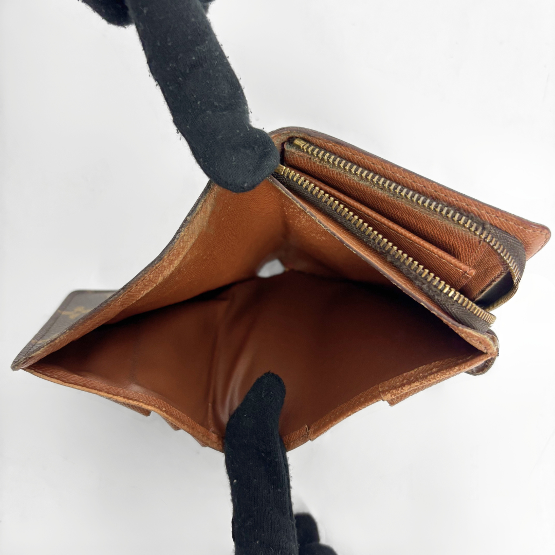 LV compact wallet in signature brown monogram canvas with a snap-button strap closure.