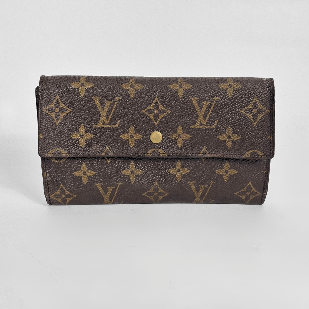 Designer wallet with monogram pattern on a light gray background