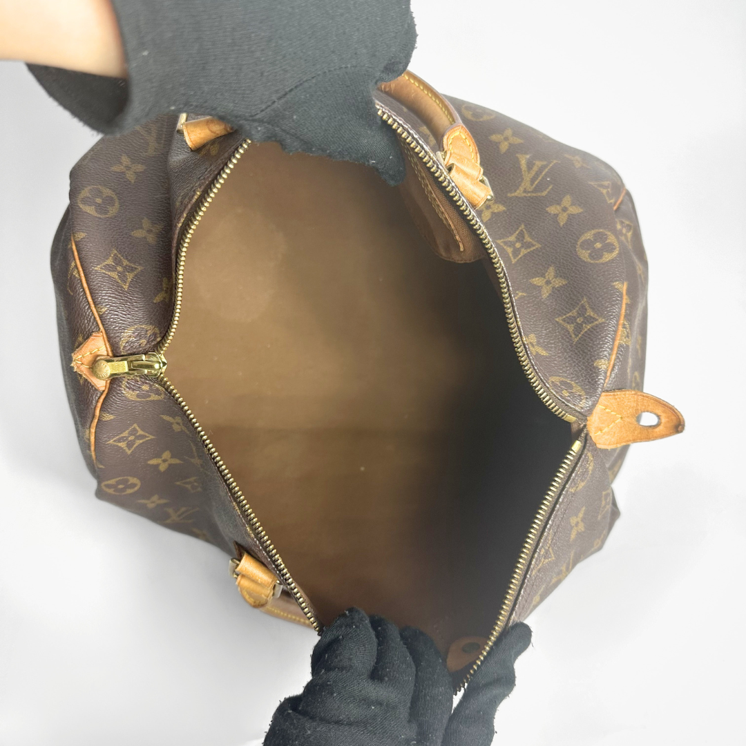 Brown handbag with a monogram pattern on a white background