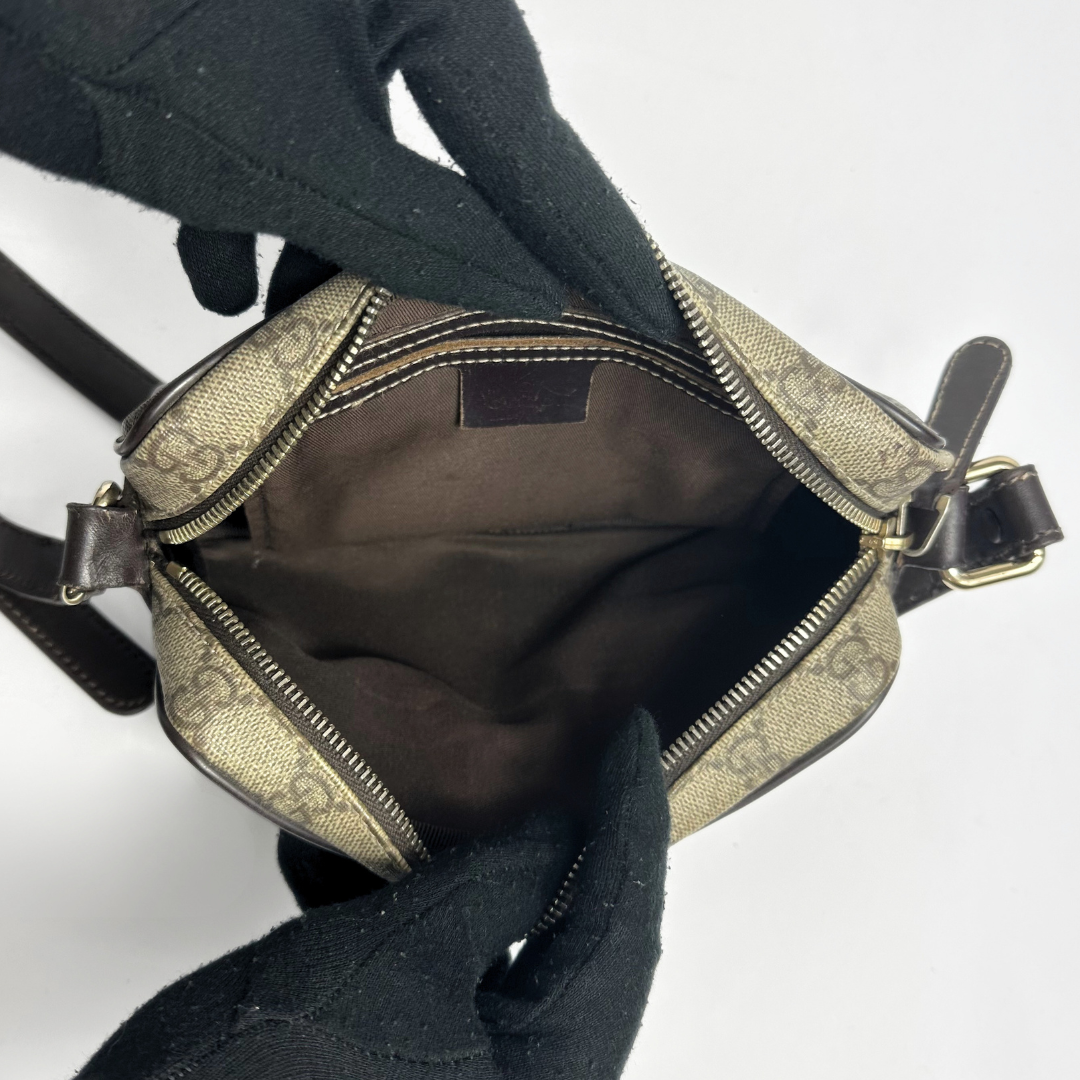 Gucci handbag with monogram pattern on a light gray background
