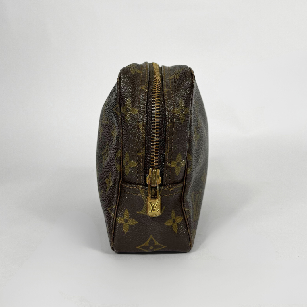 Brown leather toiletry bag with gold zipper and logo on a white background