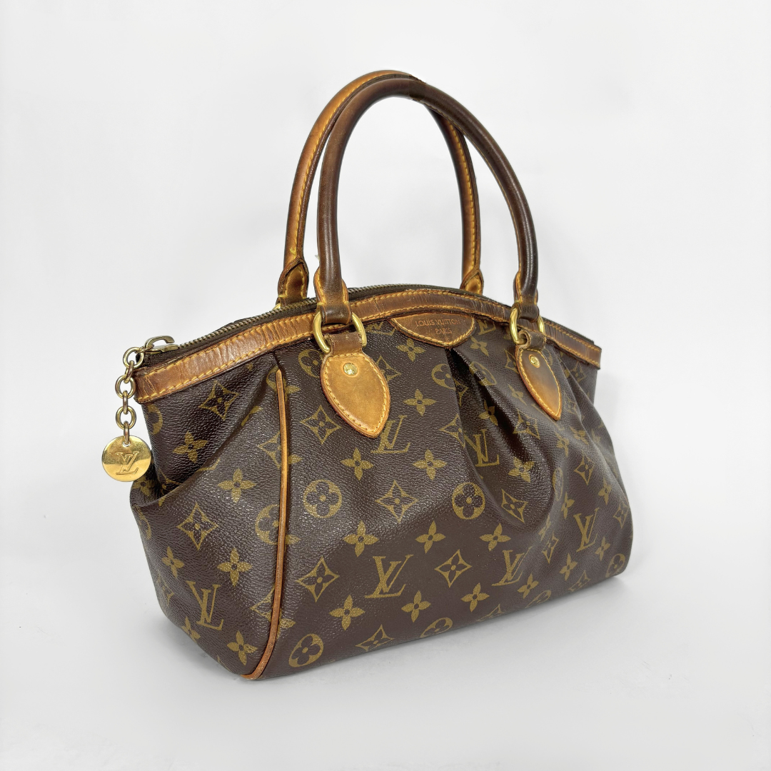 Brown handbag with gold accents on a white background