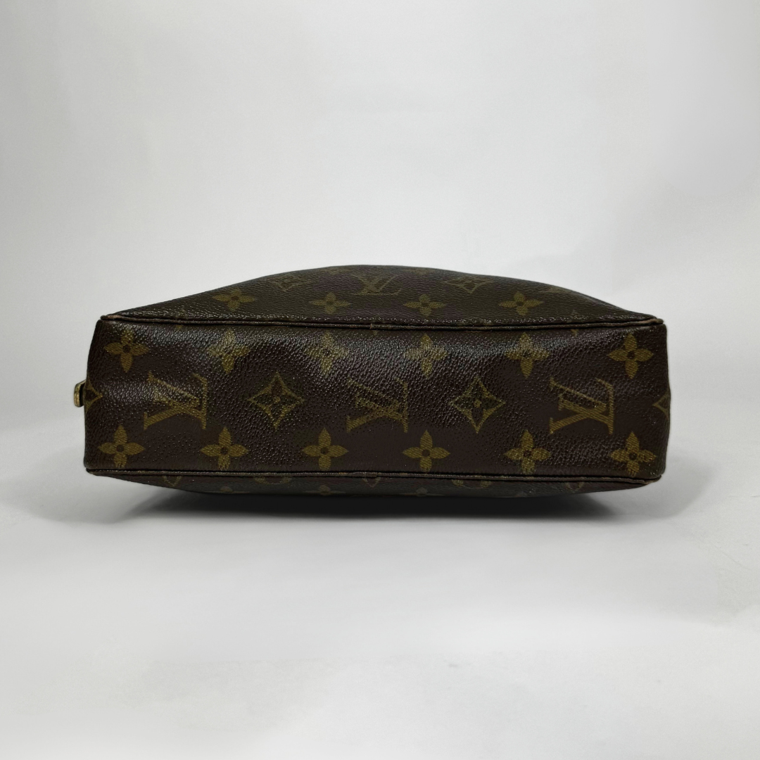 Brown leather handbag with monogram pattern on a white background