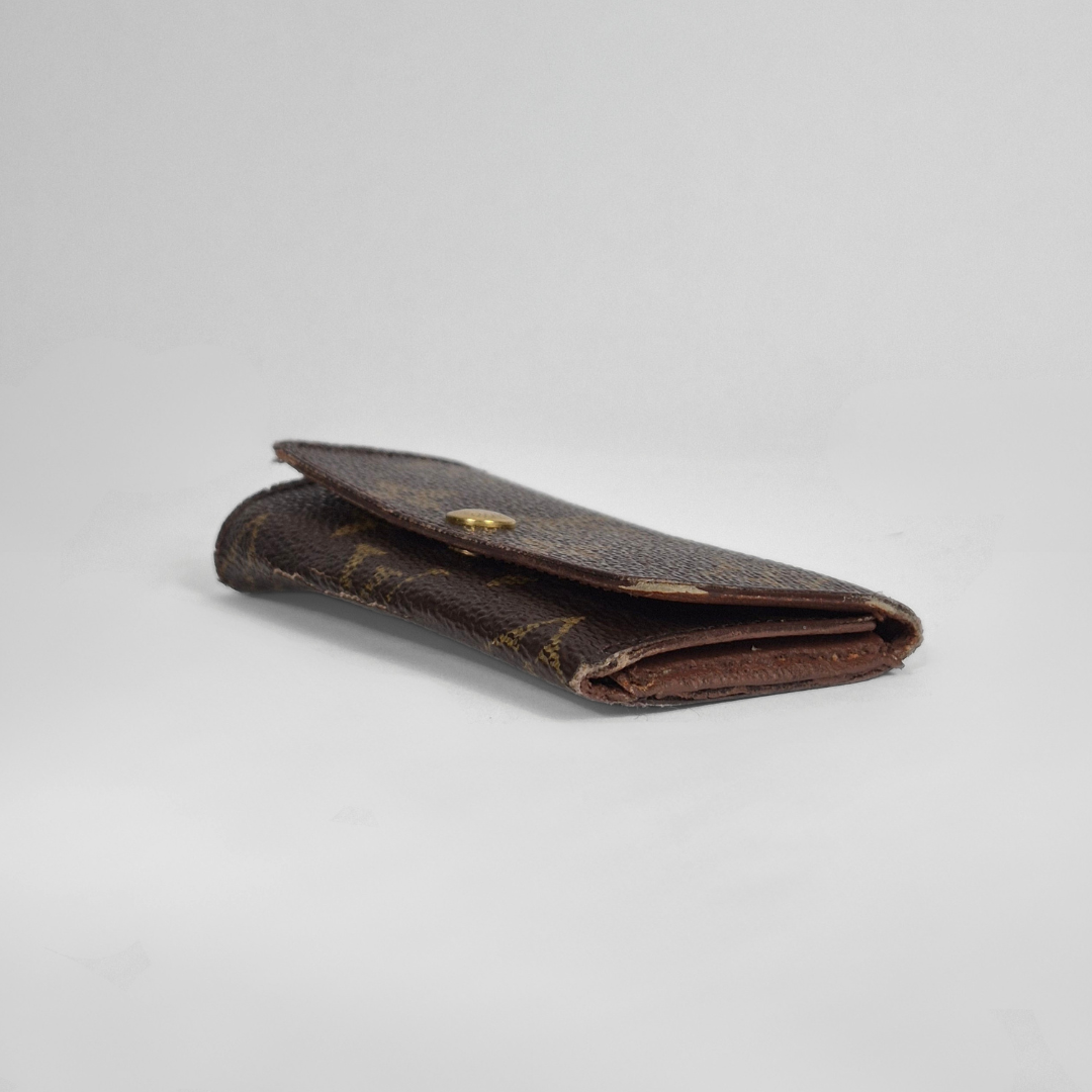 Louis Vuitton wallet with monogram pattern on white background