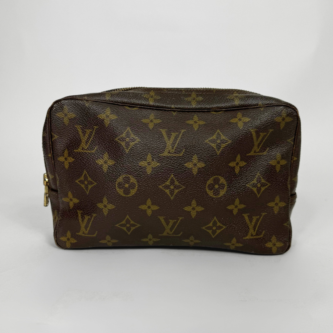 Brown leather pouch with gold monogram pattern on a white background