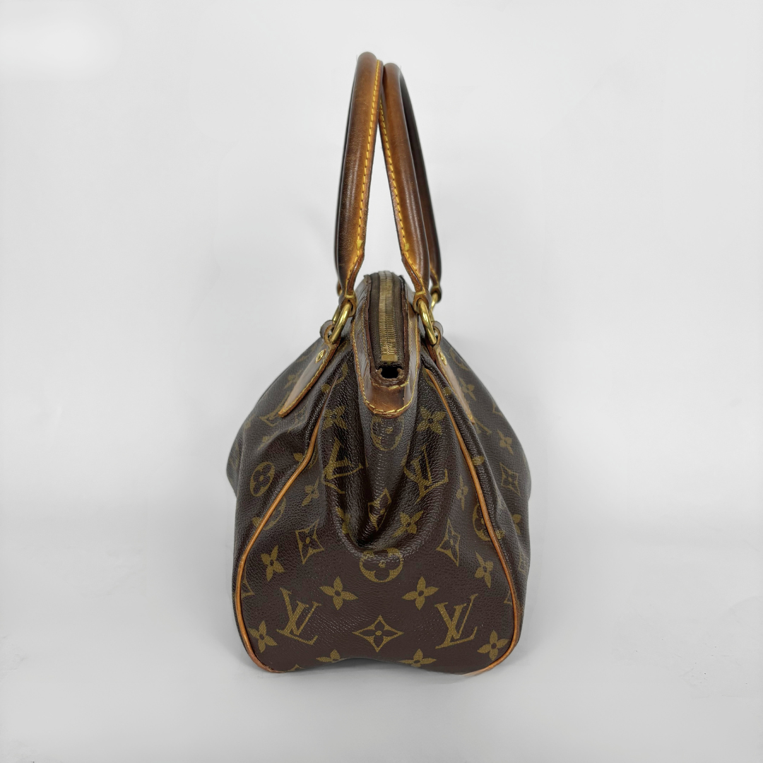 Brown handbag with gold accents on a white background