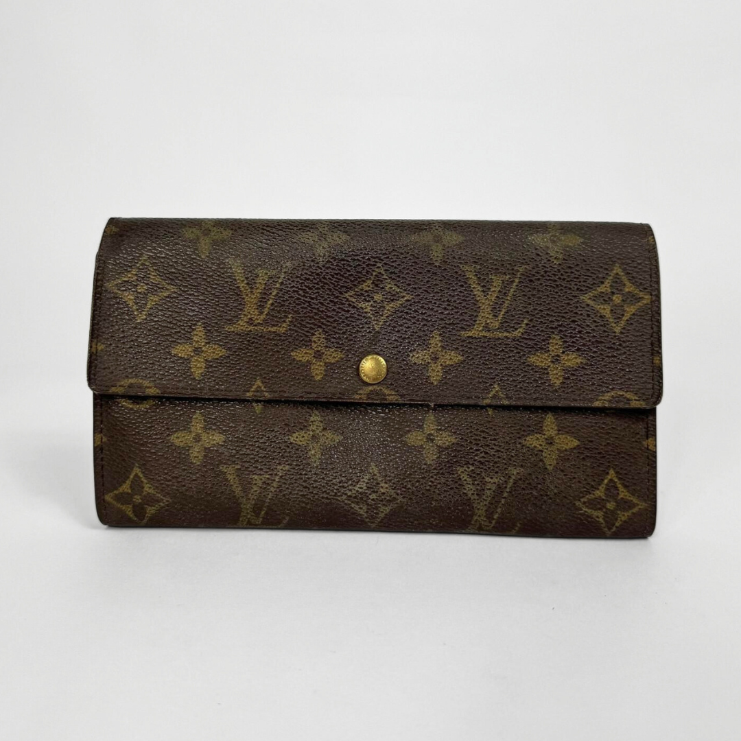 Brown wallet with gold monogram pattern on a white background
