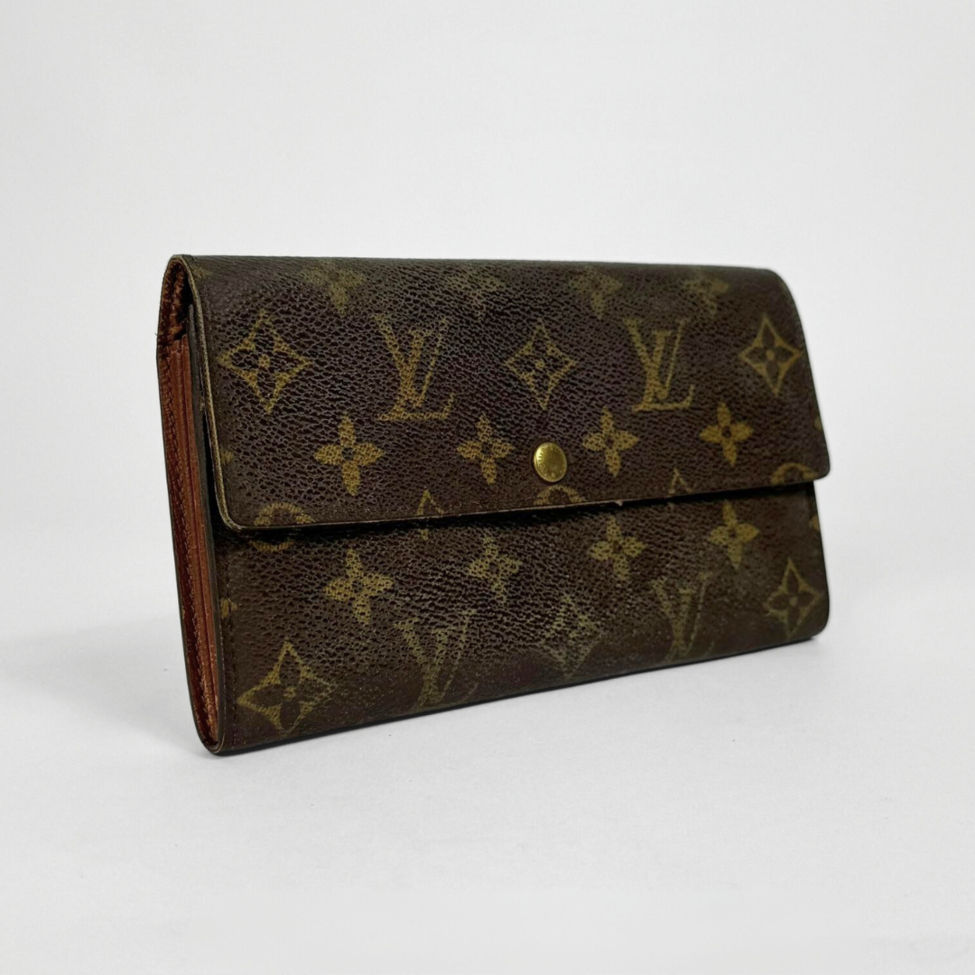 Brown wallet with gold monogram pattern on a white background