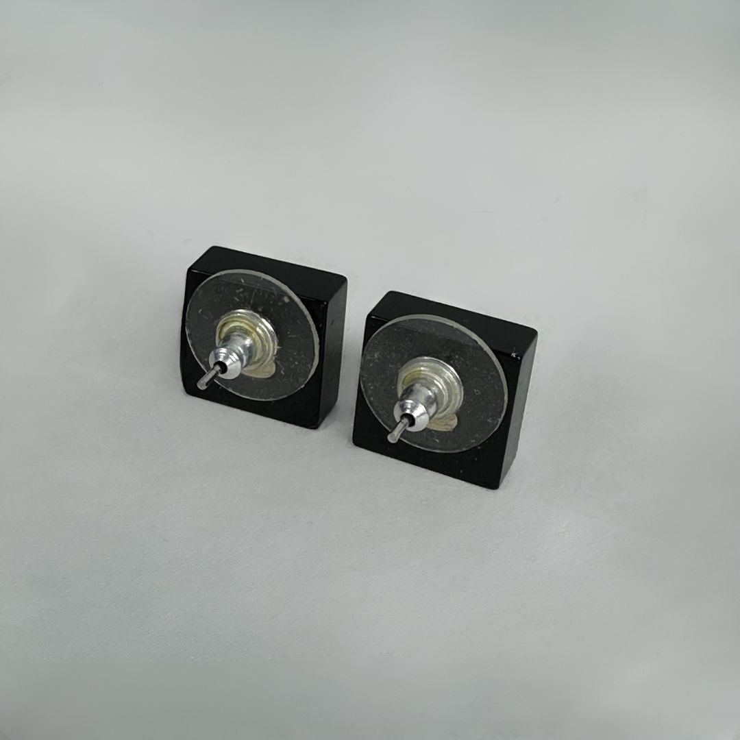 Chanel black earrings on white background