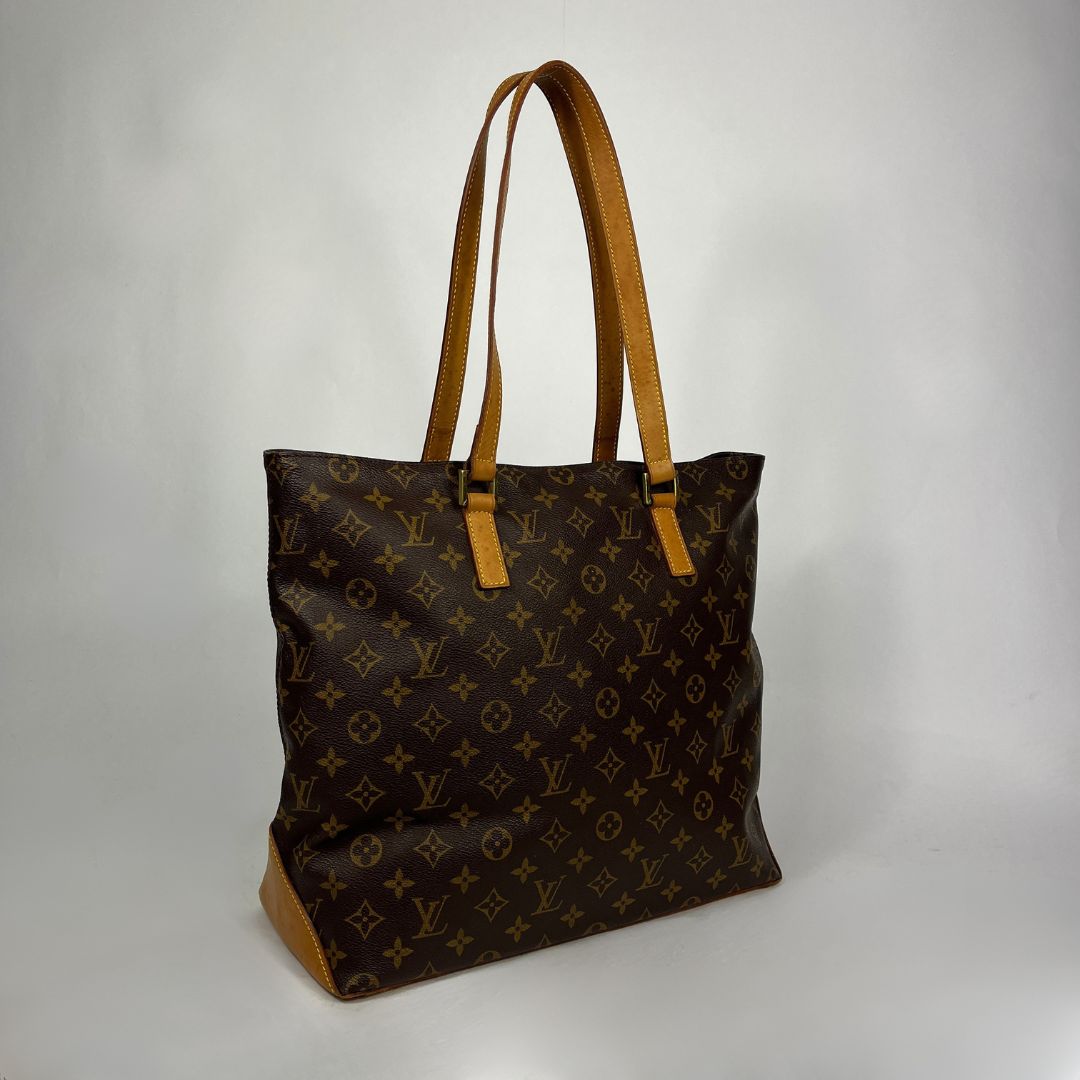 A Louis Vuitton monogram canvas tote bag with tan leather shoulder straps and trim, photographed on a light gray studio background.