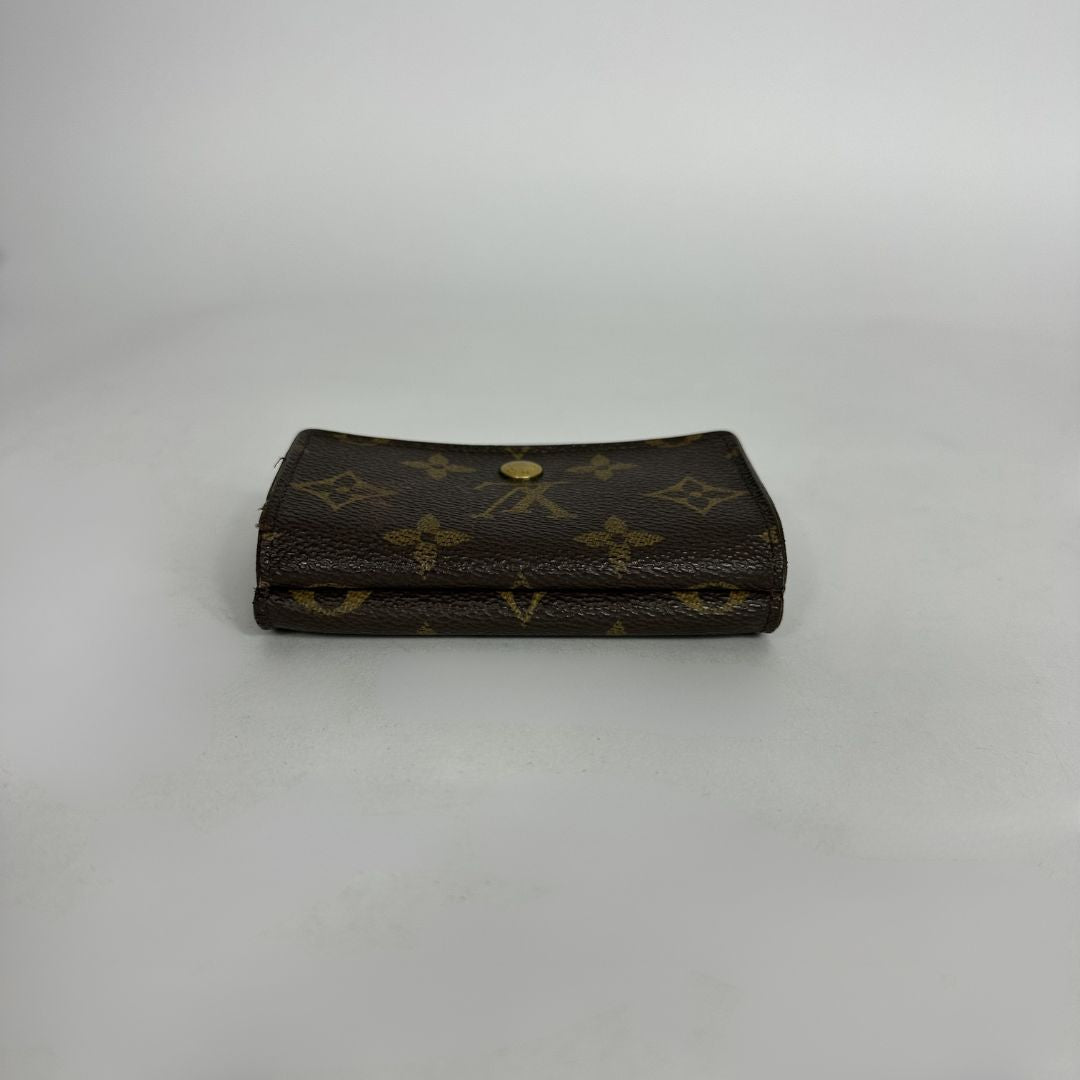 Louis Vuitton wallet with monogram pattern on a white background