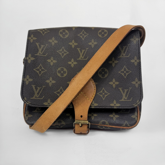 Louis Vuitton monogram canvas shoulder bag with a tan leather strap and front buckle detail, photographed on a light gray background.