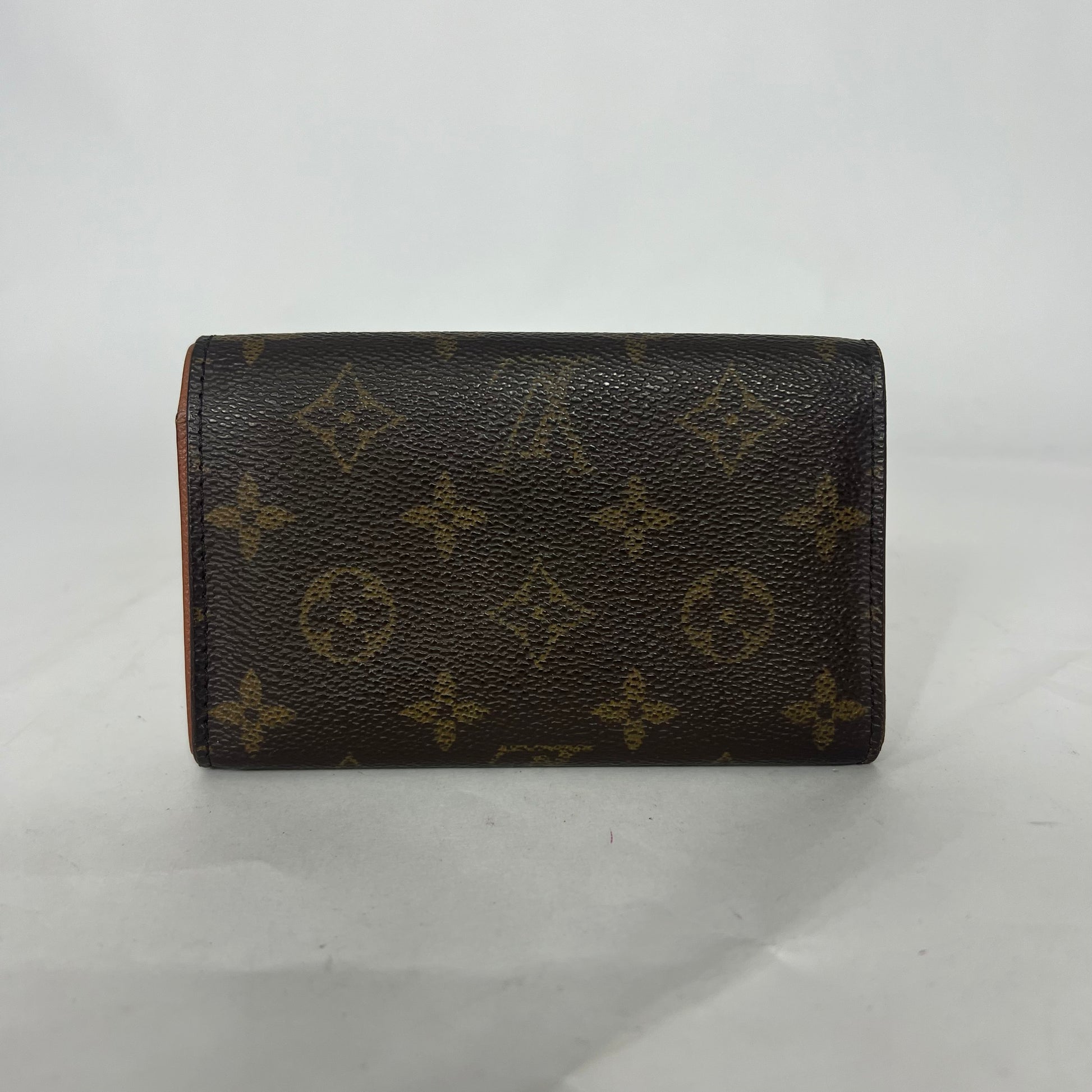 Louis Vuitton wallet with monogram pattern on a white background