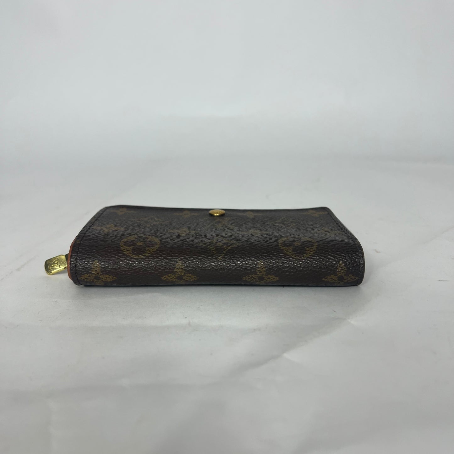 Black leather wallet with gold accents on a white background