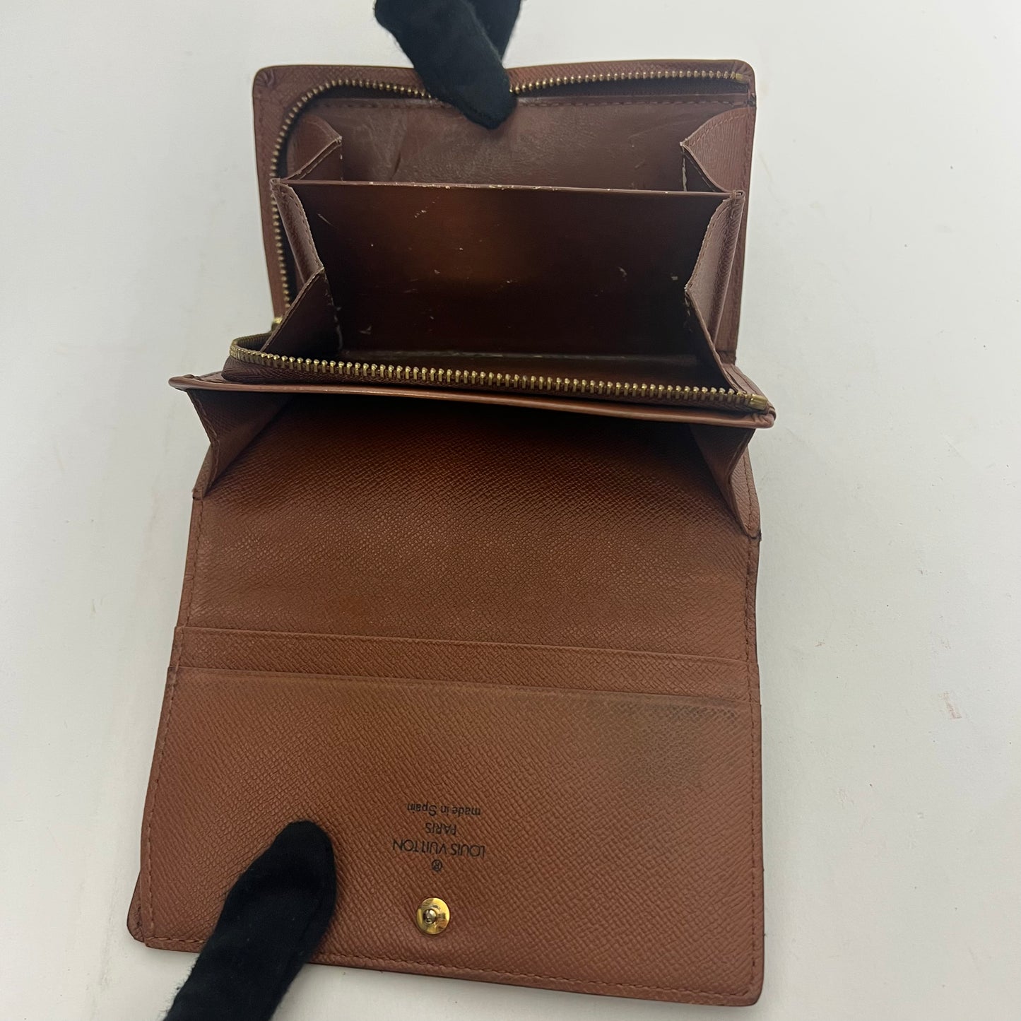 Brown leather wallet with gold zipper on a white background