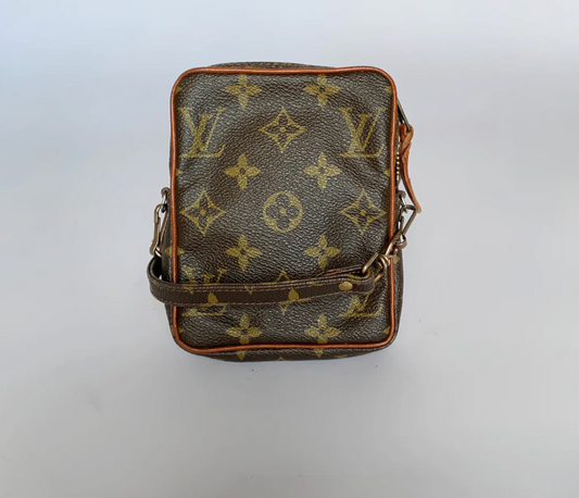 Black leather bag with brown monogram pattern on a white background